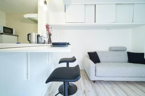 Il dispose d'une cuisine et d'un salon avec une chaise et un canapé. dans l'établissement L'Escale, à Marseille