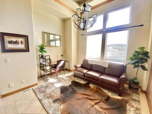 a living room with a leather couch and a window at Luxury home w a View- biking and hiking near in Pocatello
