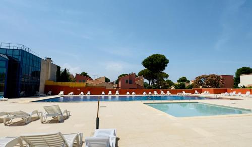 une piscine avec des chaises longues et une piscine dans l'établissement Les Trois Terrasses, à Argelès-sur-Mer