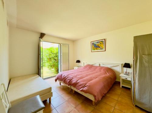 une chambre avec un grand lit et une fenêtre dans l'établissement Les Trois Terrasses, à Argelès-sur-Mer