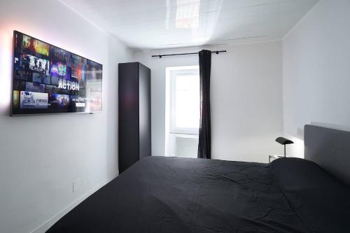 une chambre avec un lit noir et une fenêtre dans l'établissement L'Escale, à Marseille