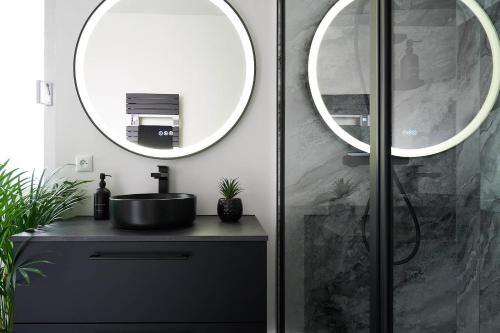 une salle de bain avec un lavabo et un miroir dans l'établissement L'Escale, à Marseille