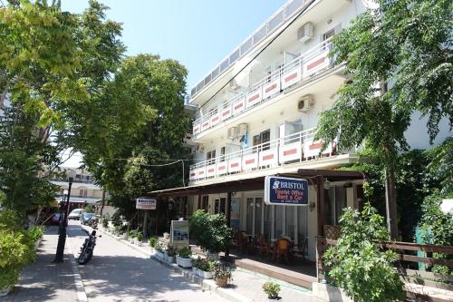 a large white building with a sign that reads grand hotel at Bristol Apartments in Kos