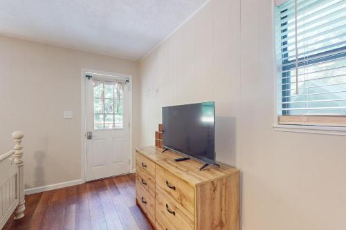 a living room with a flat screen tv on a wooden dresser at Poppy’s farmhouse in Blue Ridge
