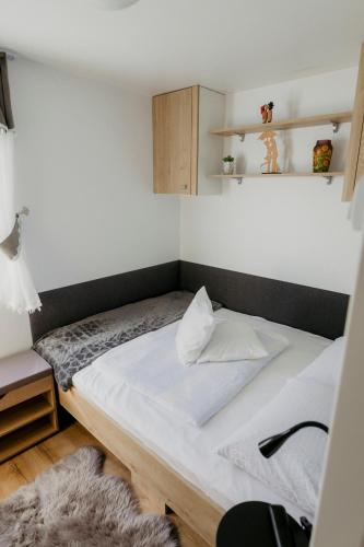 a small bedroom with a bed in a room at Mobile Home CARMINO in Turda
