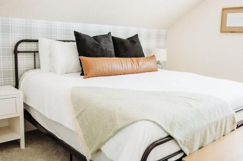 a bedroom with a large bed with black and white pillows at Creekside Cabin Magnolia-stay w views near Lava in McCammon