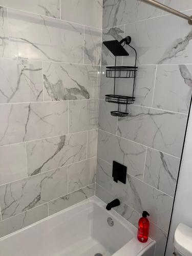 a white bathroom with a white tub and marble walls at Spacious 4-Bedroom Retreat in Kankakee, IL in Kankakee