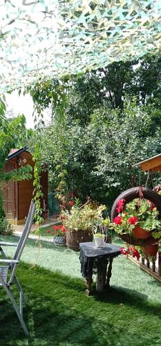 a garden with a table and a chair and flowers at Smestaj sa bazenom Sunny Hill in Smederevska Palanka