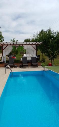 a swimming pool with chairs and a gazebo at Smestaj sa bazenom Sunny Hill in Smederevska Palanka
