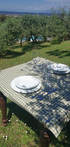 a picnic table with plates and wine glasses on it at Agriturismo Cascina Cipressa in San Romano