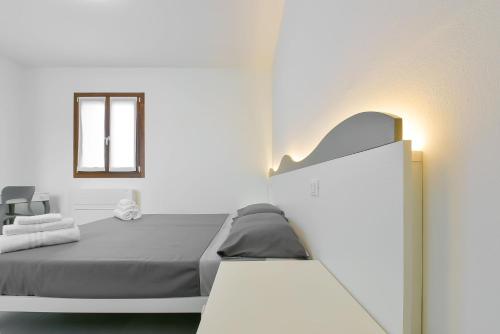a white bedroom with a bed and a window at Queen Venice Fly Apartments in Campalto