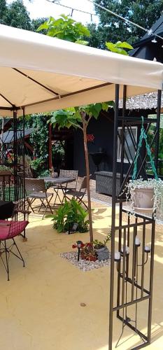 a patio with a white umbrella and a table and chairs at Smestaj sa bazenom Sunny Hill in Smederevska Palanka