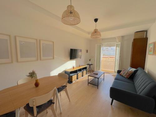 a living room with a table and a blue couch at Apartamento La Botica garaje incluido in Huelva