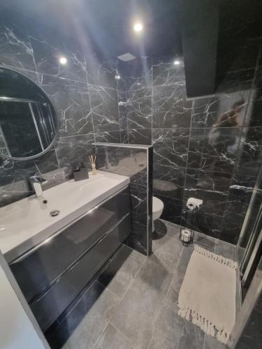 une salle de bain avec une baignoire, un lavabo et un miroir dans l'établissement Maison Centre Ville avec jardin, à Agen