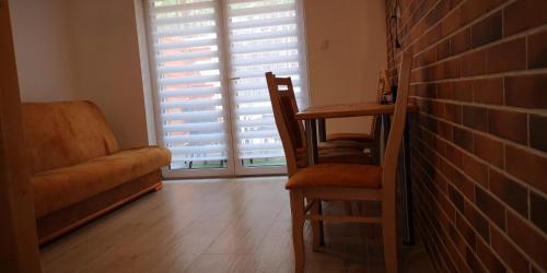 a living room with a chair and a brick wall at Extra Apartament Leśny Miodek Sielpia Wielka in Sielpia Wielka