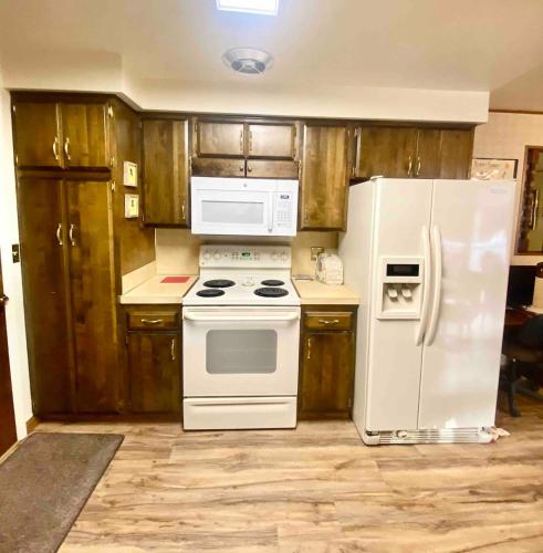 a kitchen with white appliances and wooden cabinets at Roomy Midtown Home-Large and Central to Everything in Pocatello
