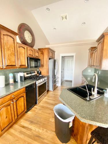 a kitchen with wooden cabinets and a clock on the wall at Spacious open home near hospital and university in Pocatello