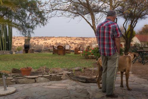a man standing next to two deer in a yard at Halala Africa Lodge - Eagle Rock Lodge in Malabar
