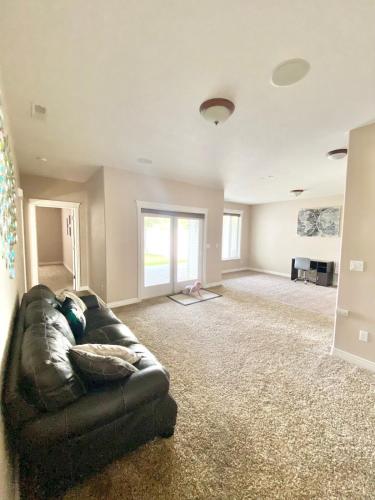 a living room with a black leather couch at Spacious open home near hospital and university in Pocatello