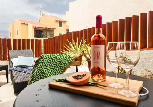 a bottle of wine and a glass on a table at Papaya Apartments Sal Island in Santa Maria
