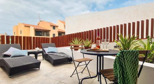 a patio with a table and chairs and a fence at Papaya Apartments Sal Island in Santa Maria