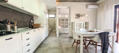 a kitchen with white cabinets and a table and chairs at Papaya Apartments Sal Island in Santa Maria
