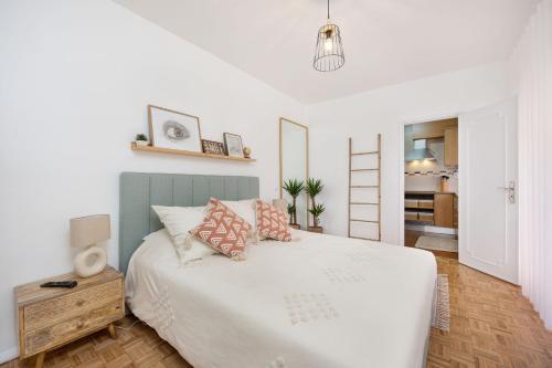 a bedroom with a white bed with pillows on it at Maré Baixa Oceanside Apartment in Nazaré