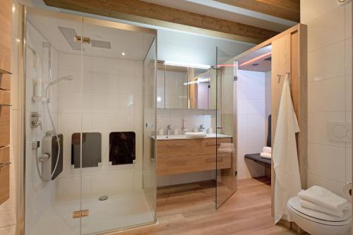 a bathroom with a shower and a toilet and a sink at Resort Tirol Brixen am Sonnenplateau in Brixen im Thale