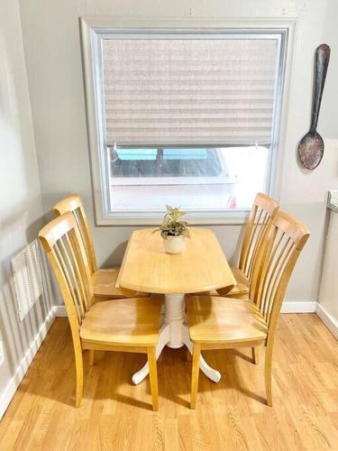 a wooden table and chairs in a room with a window at Comfy Pocatello home-central to park and grocery in Pocatello