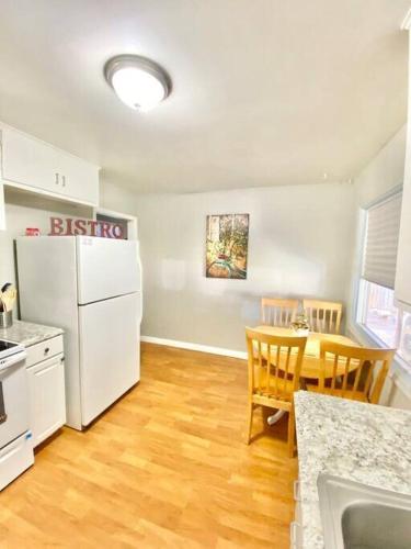 a kitchen with a table and a white refrigerator at Comfy Pocatello home-central to park and grocery in Pocatello