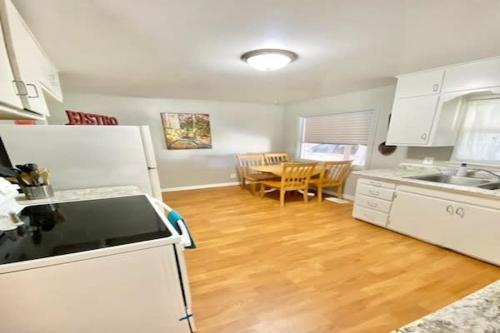 a kitchen with white appliances and a wooden floor at Comfy Pocatello home-central to park and grocery in Pocatello