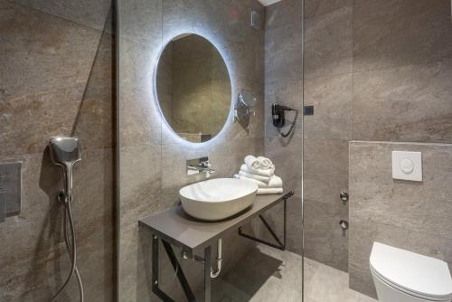 a bathroom with a sink and a mirror at Hotel Squero in Rovinj