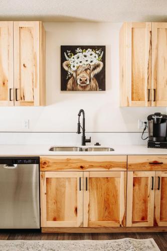 a kitchen with a sink and a picture of a cow at Creekside Cabin Magnolia stay w views and hot springs ONE br in McCammon