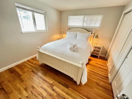 una camera da letto con un grande letto bianco con due finestre di Newly Renovated Home w Garage Near Old Town a Pocatello