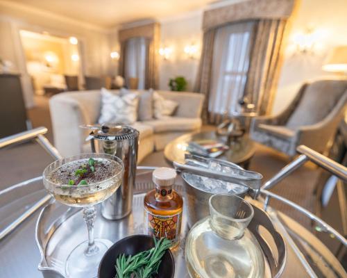 a living room with a glass table with wine glasses at Southern Sun The Cullinan in Cape Town