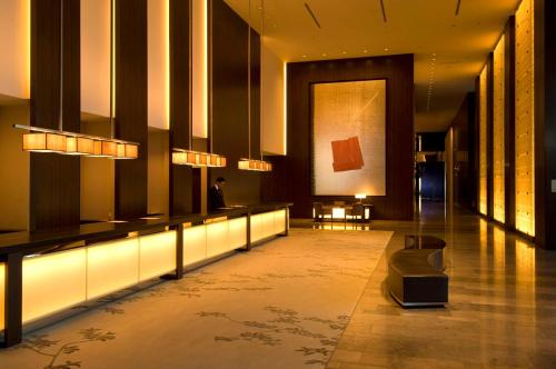 a lobby of a building with a painting on the wall at Conrad Tokyo in Tokyo