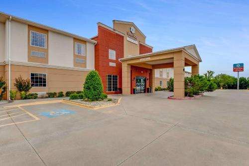 a hotel parking lot in front of a building at SureStay Plus Hotel by Best Western Owasso Tulsa North in Owasso