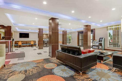 a living room with a couch and a table at SureStay Plus Hotel by Best Western Owasso Tulsa North in Owasso