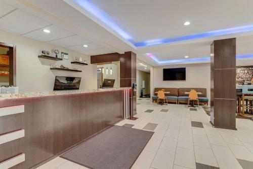 a lobby with a bar and a dining area at SureStay Plus Hotel by Best Western Owasso Tulsa North in Owasso