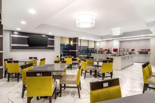 Un comedor con mesas y sillas amarillas. en Best Western Plus Houston Energy Corridor, en Houston