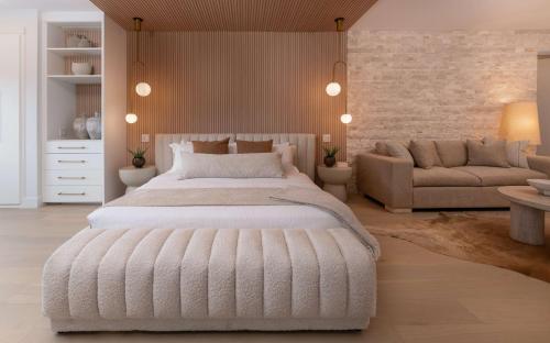 a bedroom with a large white bed and a couch at Prestige Beach House, WorldHotels Crafted in Kelowna