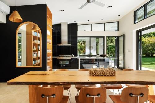 a dining room with a large wooden table and chairs at Pine Mountain - luxury rural estate with pool in Binna Burra