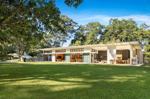 a house with a green lawn in front of it at Pine Mountain - luxury rural estate with pool in Binna Burra