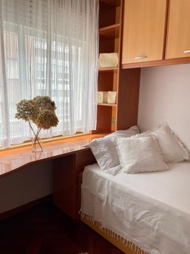 a bedroom with a bed and a window with a plant at Lar da Amarella in Ribeira