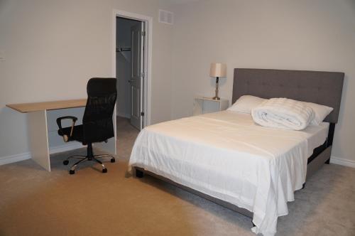 a bedroom with a bed and a desk and a chair at Fully Furnished Room in Serene Environment in Orleans
