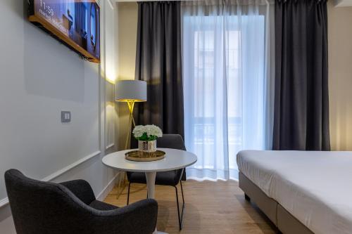 a hotel room with a bed and a table and chairs at Casa Lounge Costituzione in Cagliari
