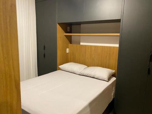 ブラジリアにあるFLAT HOTEL - PRÓXIMO AO AEROPORTO DE Brasíliaの木製のヘッドボードが付いたベッドのある小さな寝室