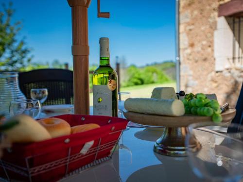a table with a basket of food and a bottle of wine at Le Tourel in Saint-Cernin-de-lʼHerm