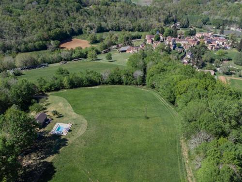 an overhead view of a large green field with a house at Le Tourel in Saint-Cernin-de-lʼHerm