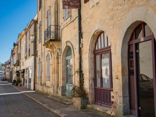 an old brick building on the side of a street at Le Tourel in Saint-Cernin-de-lʼHerm